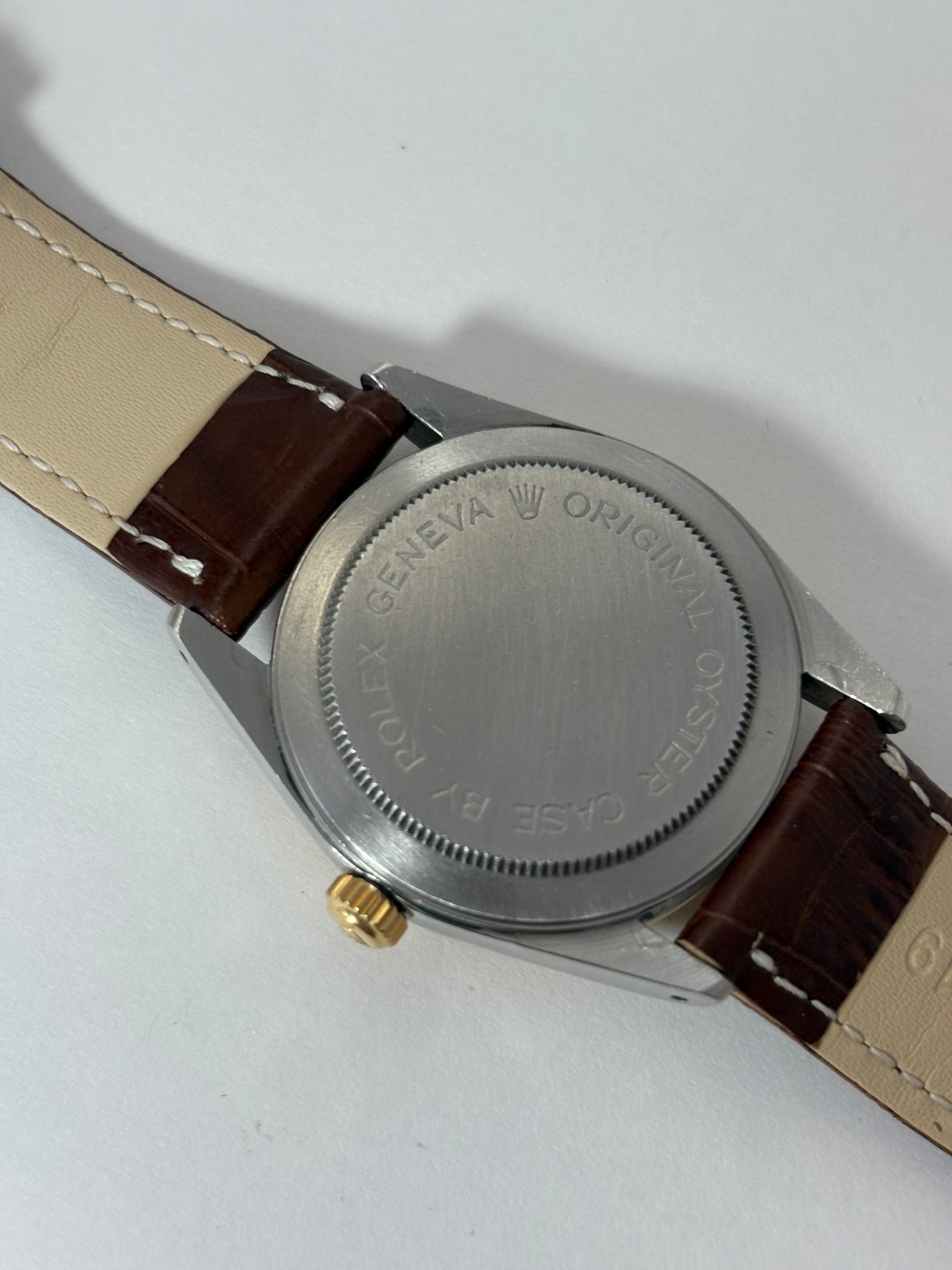Close-up of a Tudor-Rolex watch with a brown strap on a white background