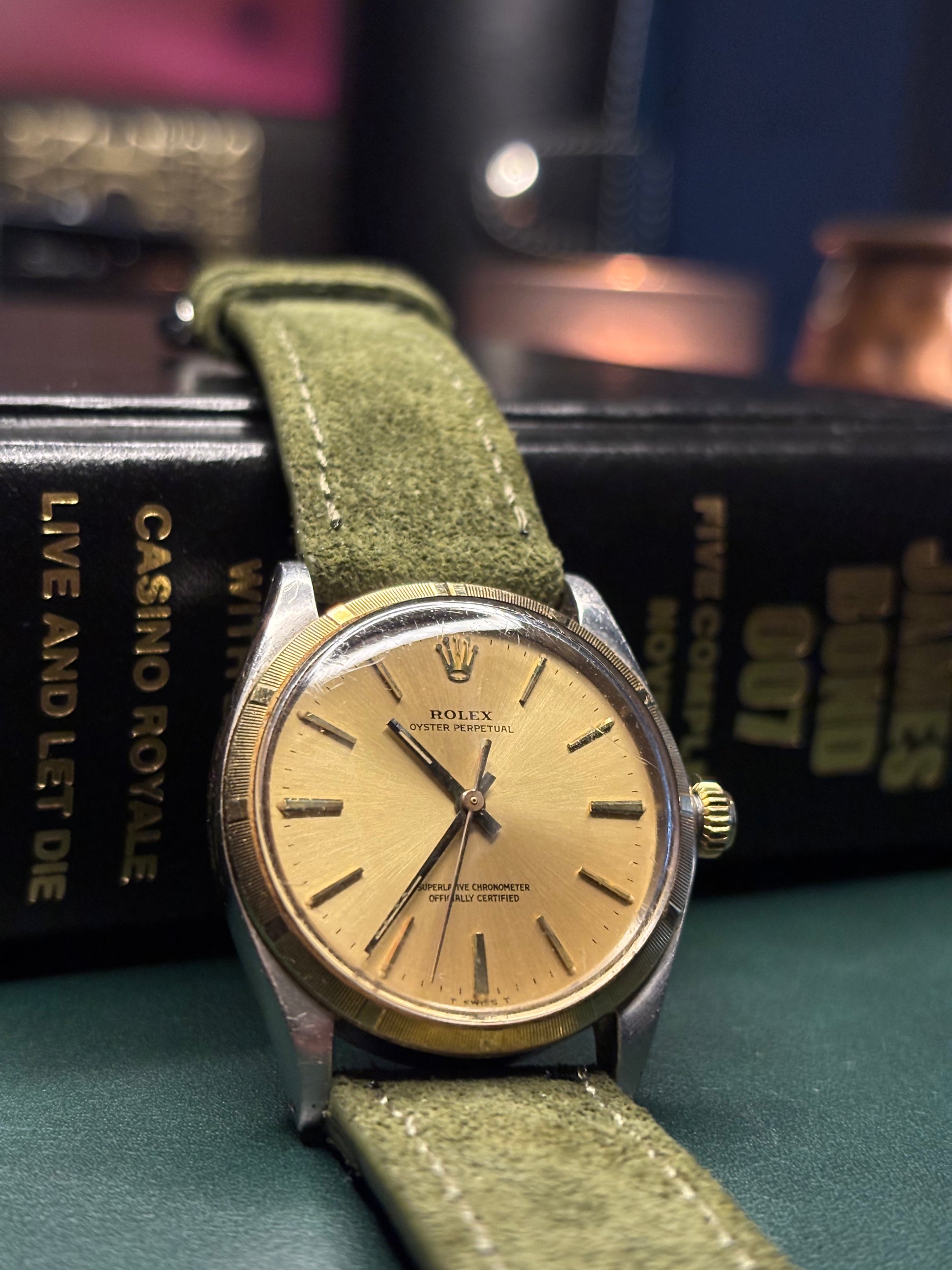 Vintage Rolex watch with a green strap on a book titled 'Casino Royale'.