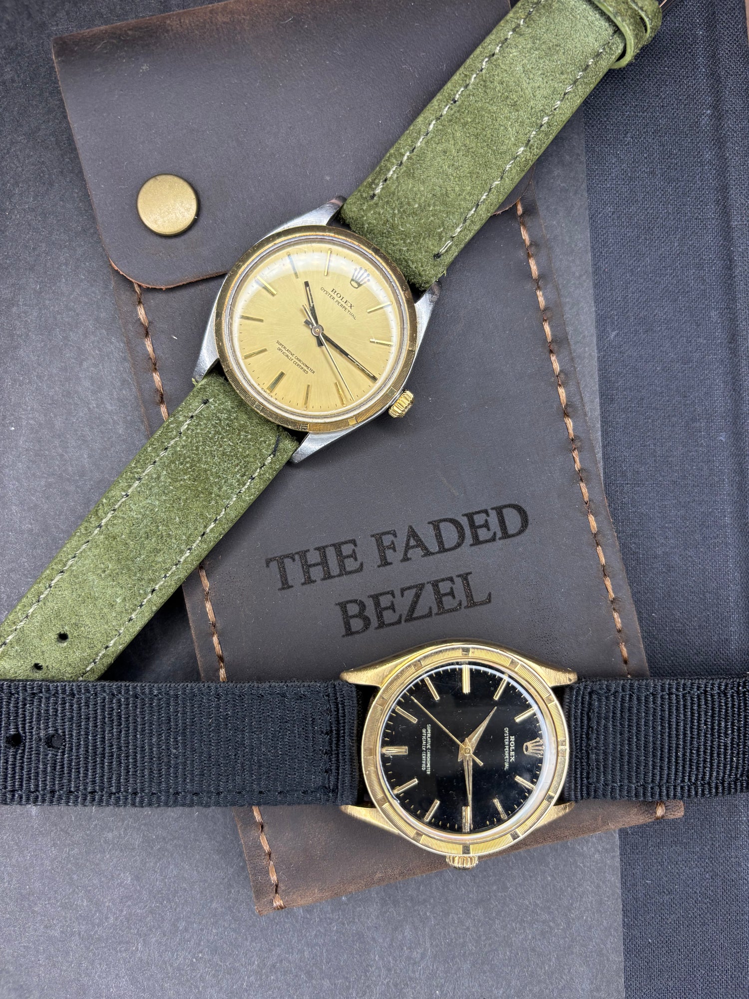 Two Swiss made mechanical vintage Rolex watches with gold bezels on a watch travel pouch with 'The Faded Bezel' branding.